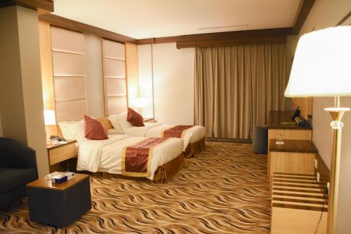 a hotel room with two beds and a television at Florida Inn Hotel in Najran