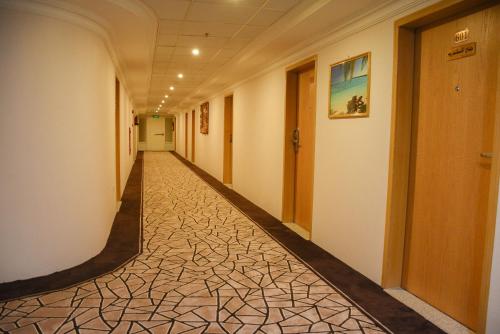 an empty hallway in a building with a tile floor at Florida Inn Hotel in Najran