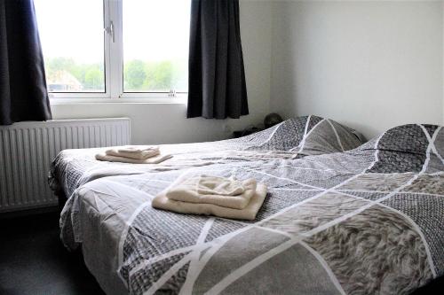een slaapkamer met 2 bedden en handdoeken bij Panorama Chalet in Drijber