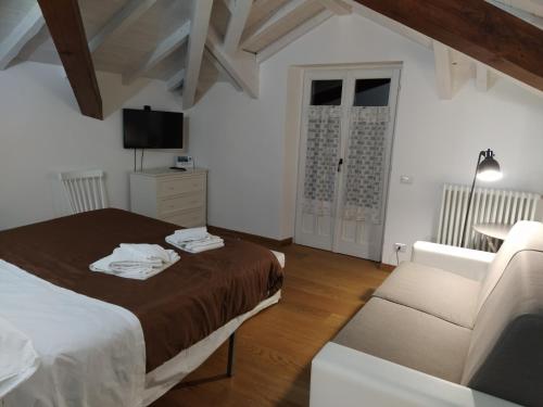 ein Schlafzimmer mit einem Bett und einem Sofa in der Unterkunft Villa Peachey (Picci), Grazioso Appartamento in Stresa