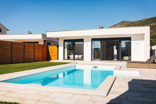 a swimming pool in front of a house at olive tree house in Mostar