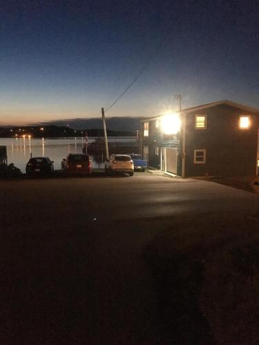 a building with cars parked in a parking lot at night at Toulinguet Inn - Suites in Twillingate
