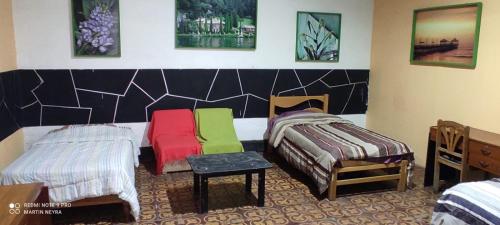 a bedroom with two beds with colorful blankets and a table at Enkanta Guest House in Trujillo
