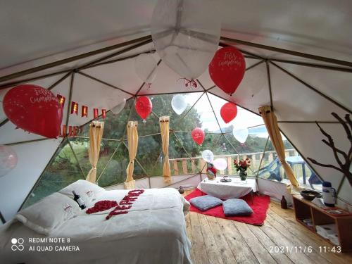sypialnia w namiocie z łóżkiem i balonami w obiekcie Skyline Glamping Guasca w mieście Guasca