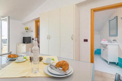 a kitchen with a table with a bottle of wine and dishes at Residence Kamenjak in Premantura