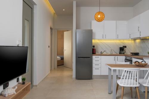 a kitchen with a refrigerator and a table at Aegean Breeze Luxury Apartments next to the sea in Maleme