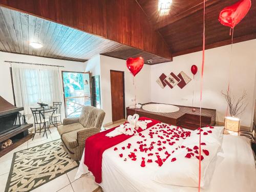 a bedroom with a bed with red hearts on it at Pousada Flor de Ipe in São Bento do Sapucaí