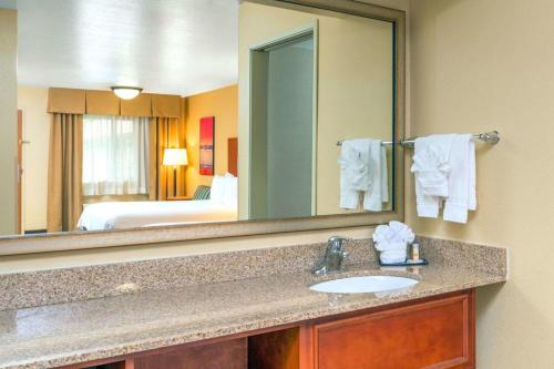 ein Badezimmer mit einem Waschbecken und einem großen Spiegel in der Unterkunft Independence 47 Hotel in Scottsdale