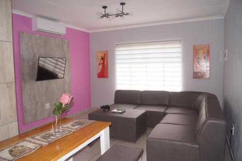 una sala de estar con un sofá y una mesa en Rhino House with 3 bedrooms next to Pilanesberg and Sun City, en Mogwase