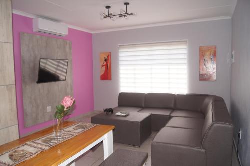 a living room with a couch and a table at Rhino House with 3 bedrooms next to Pilanesberg and Sun City in Mogwase