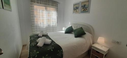 a bedroom with a bed with green and white pillows at Anacasa Puerto Explanada Cervantes AP1102 in Denia