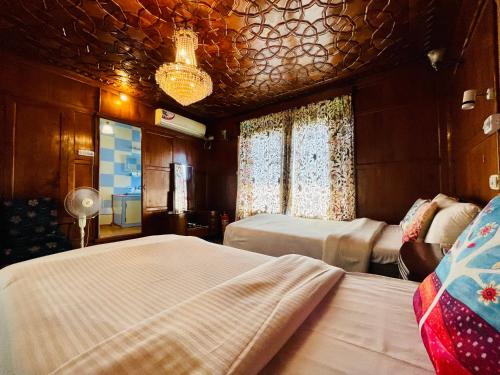 a bedroom with two beds and a chandelier at Dilshad Houseboats in Srinagar