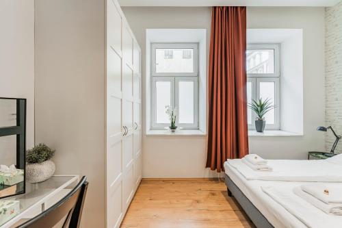sypialnia z łóżkiem i dwoma oknami w obiekcie ZEUS Design Apartments Herz w Wiedniu