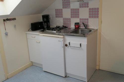 une petite cuisine avec un évier et une cuisinière dans l'établissement Location Le Pim's à 