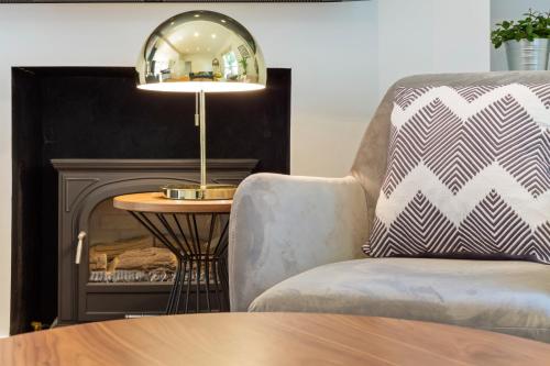 a living room with a chair and a table with a lamp at Camden Home - Barracks Properties in London