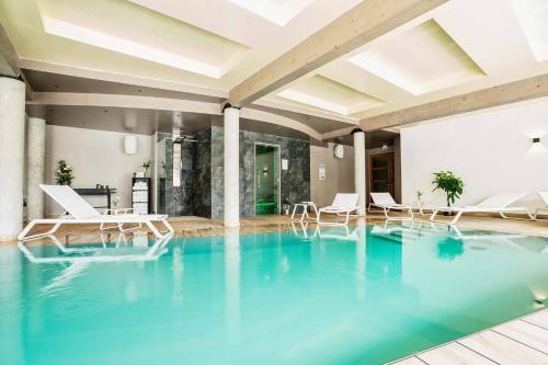une piscine avec de l'eau bleue dans un immeuble dans l'établissement Best Western Premier Hotel de la Cite Royale, à Loches