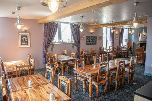 a dining room with wooden tables and chairs at The Lion Hotel in Blaenavon