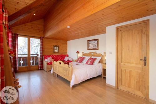 a bedroom with a bed and a wooden ceiling at 2AlpesChalets - Chalet Marie 2 - Standing et Sauna aux pieds des pistes in Les Deux Alpes