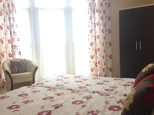 a bedroom with a bed with a flower patterned blanket at PSB Apartments in Midia Resort Aheloy in Aheloy