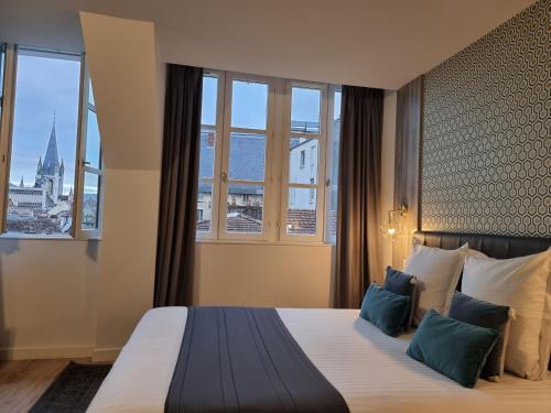 a hotel room with a bed with a large window at City Loft Apparthotel in Dijon