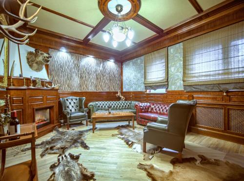 ApartHotel Hubertus في بياويستوك: غرفة معيشة مع أريكة وكراسي ومدفأة