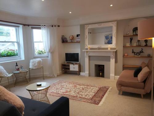 a living room with a couch and a fireplace at Seafront Apartment Private Garden & Free Parking in Littlehampton