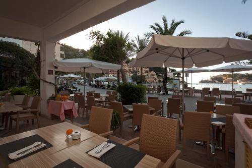a restaurant with tables and chairs with a view of the ocean at Los Geranios in Port de Soller