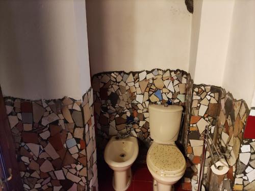 a bathroom with a toilet and a mosaic wall at Gesuiti Home - Lumina Collection in Catania