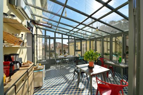 uma cozinha com um jardim de Inverno com uma mesa e cadeiras em B&B Villa Du Roc Fleuri em Cannes