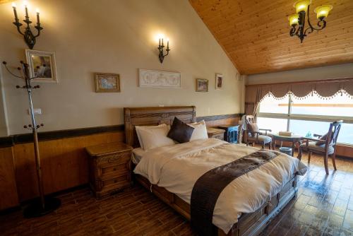 a bedroom with a bed and a table and chairs at Qingjing Baiyun Resort in Renai