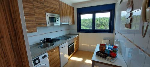 una pequeña cocina con fregadero y ventana en Olas Deluxe Salinas, en Salinas