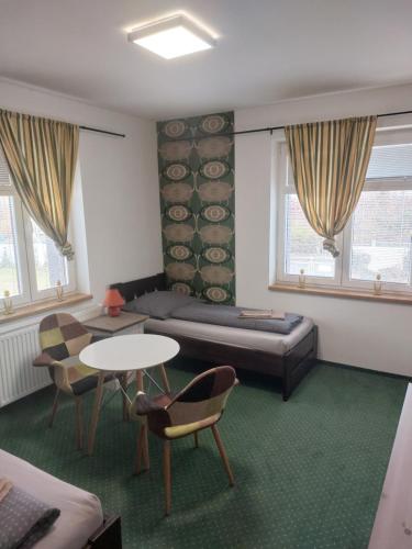 a room with a bed and a table and chairs at Kopeček - Penzion in Česká Lípa