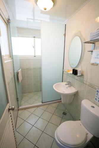 a bathroom with a shower and a toilet and a sink at Qingjing Baiyun Resort in Renai