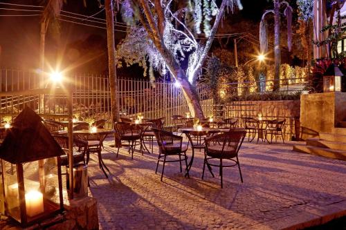 a patio with tables and chairs at night at Sant' Martre in Rio de Janeiro
