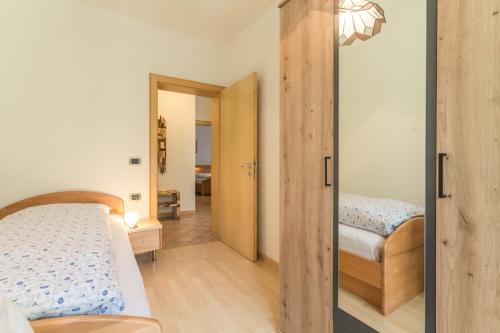 a bedroom with two beds and a sliding door at Casa Plaickner in Molini di Tures