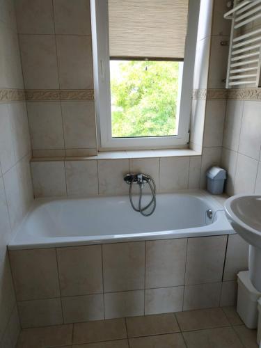 a bath tub in a bathroom with a window at mieszkanie dwupokojowe w Pucku in Puck
