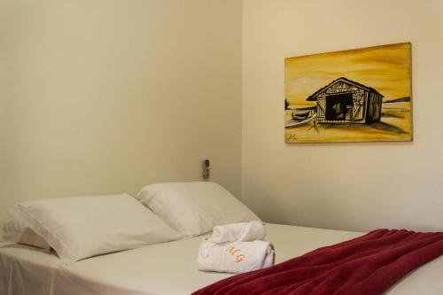 a bedroom with a bed and a painting on the wall at Morada do Gabriel in Guarda do Embaú