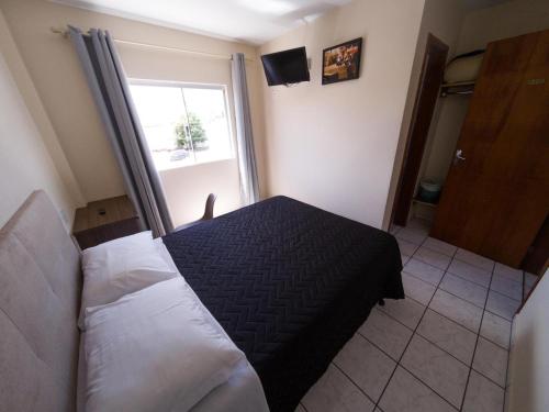a bedroom with a bed and a window at Nacional Park Hotel Lages in Lages