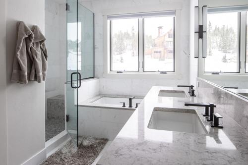 a white bathroom with two sinks and a shower at Spanish Peaks - Highlands Cabin 45 in Big Sky