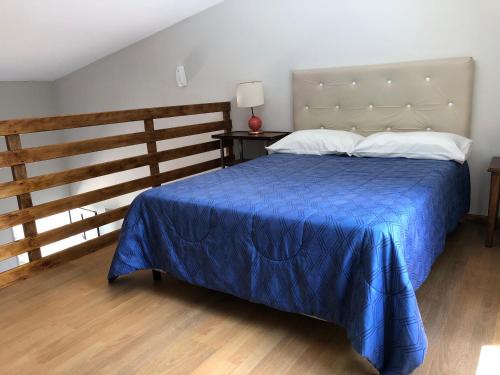a bedroom with a bed with a blue comforter at Navarro Departamentos Temporarios in Navarro