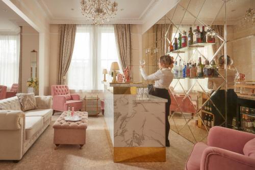 a woman standing at a bar in a living room at Bathen House Boutique Hotel in Bath