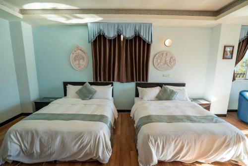 two beds in a room with blue walls at Qingjing Baiyun Resort in Renai
