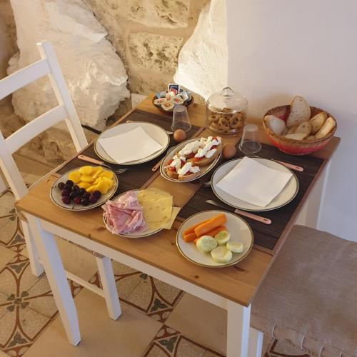 een houten tafel met borden met eten erop bij B&B Dei Cardinale in Bari