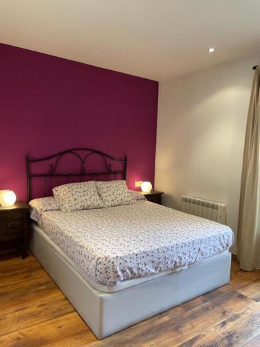 1 dormitorio con 1 cama con pared morada en GISCA, en Pauls de Flamisell