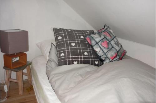 - un canapé avec deux oreillers dans l'établissement Location Le Pim's à 