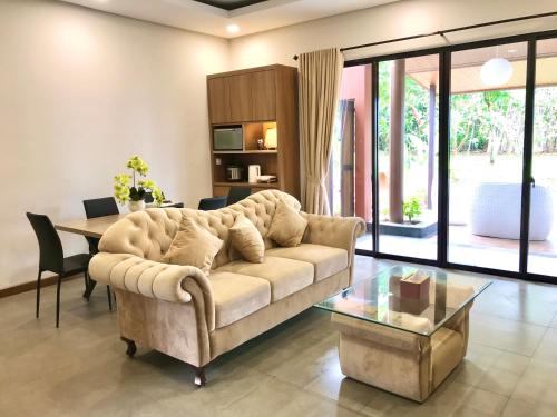 ein Wohnzimmer mit einem Sofa und einem Tisch in der Unterkunft Vimala Hills Villa 4 Bedroom with Mountain View in Bogor