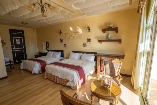 a hotel room with two beds and a table at Qingjing Baiyun Resort in Renai