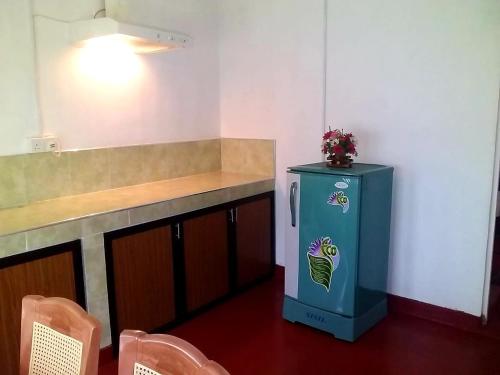 a kitchen with a counter and a blue refrigerator at Midland Hotel Rooms Kanampella in Kananpella