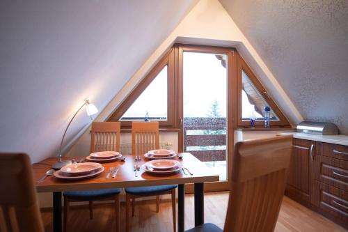 uma sala de jantar com uma mesa e cadeiras e uma janela em Golden Apartments Zakopane&B14 em Zakopane