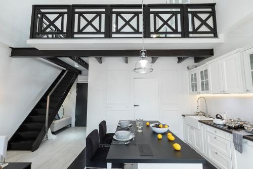 a kitchen with a black table and a staircase at Super-Apartamenty VIP Old Town in Poznań